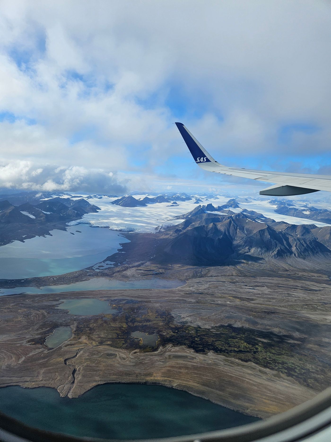 An ice cap spills between peaks to a meltwater plain