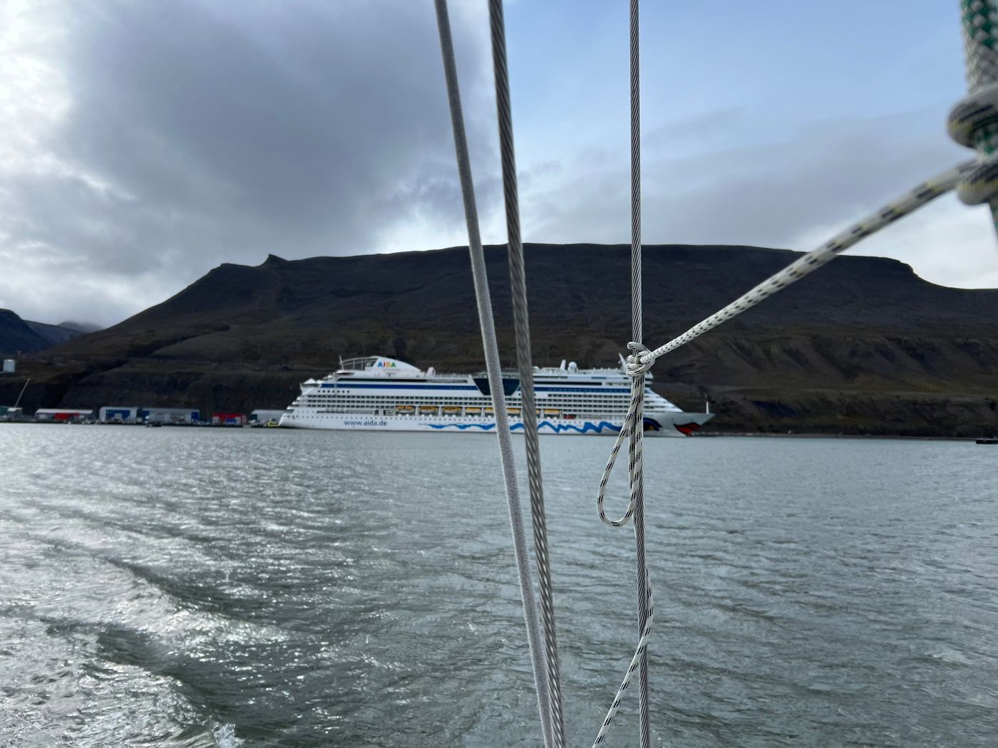 A cruise ship passes, framed by our own rigging