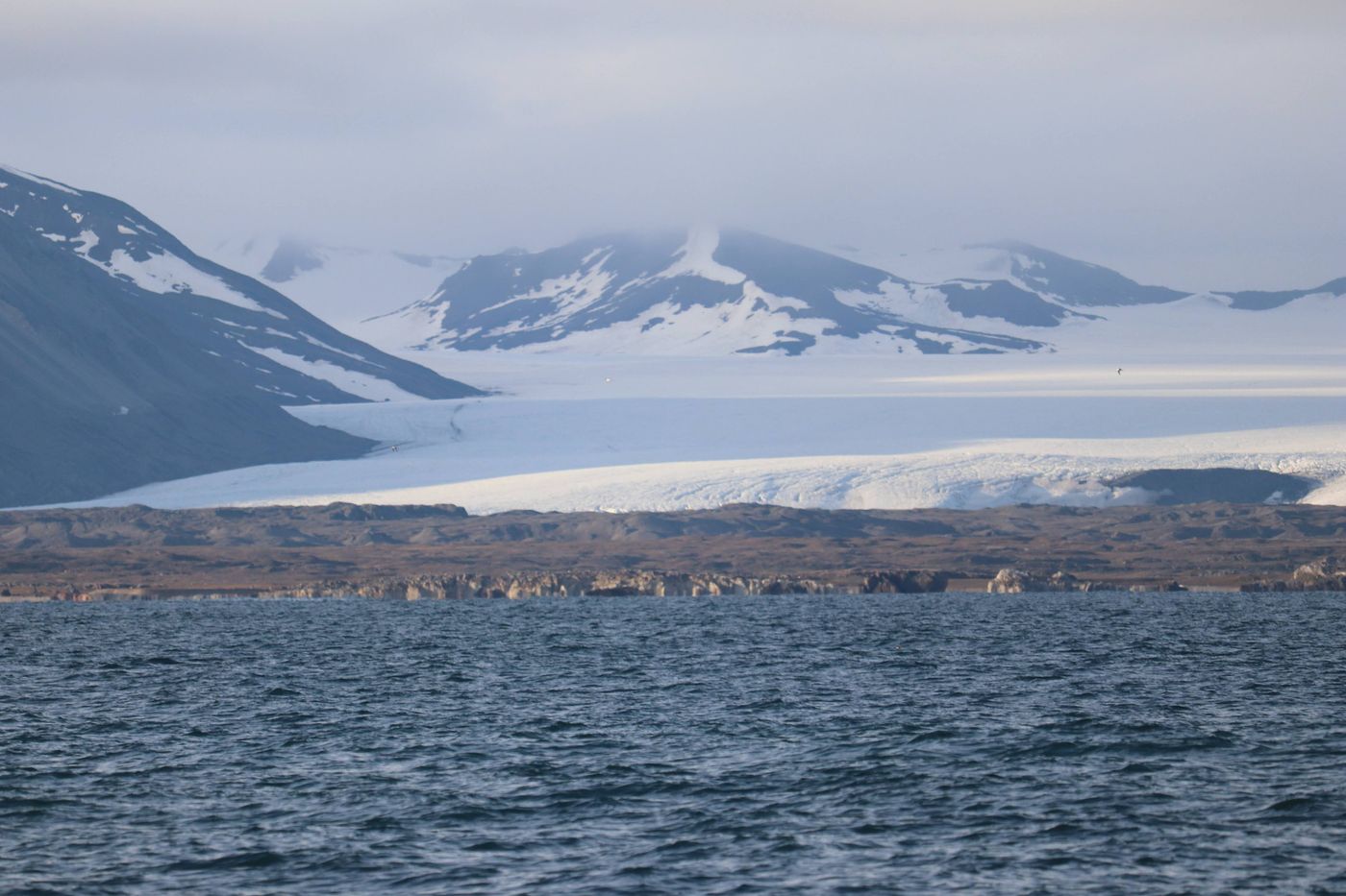 Ice pours off the mountains into the fjord