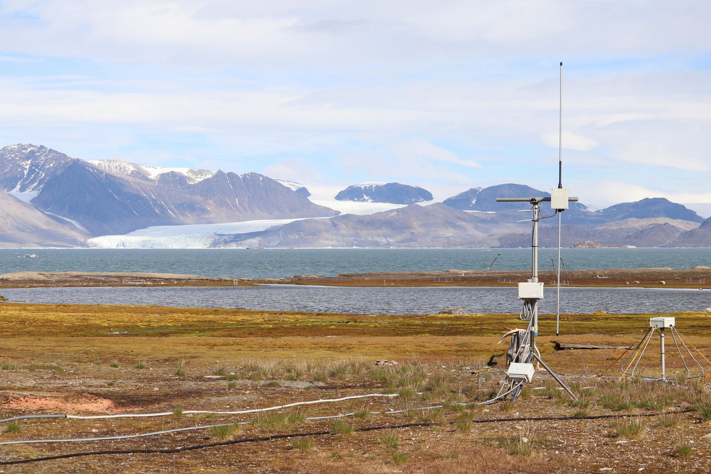 A mast on the tundra, reading the air across the fjord