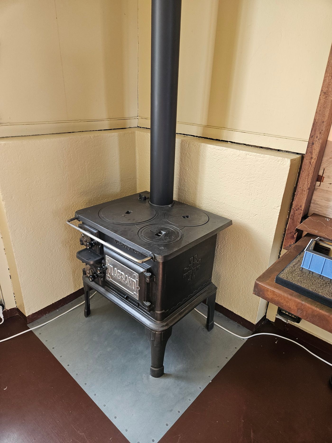 A cast-iron stove in the corner of a bare room