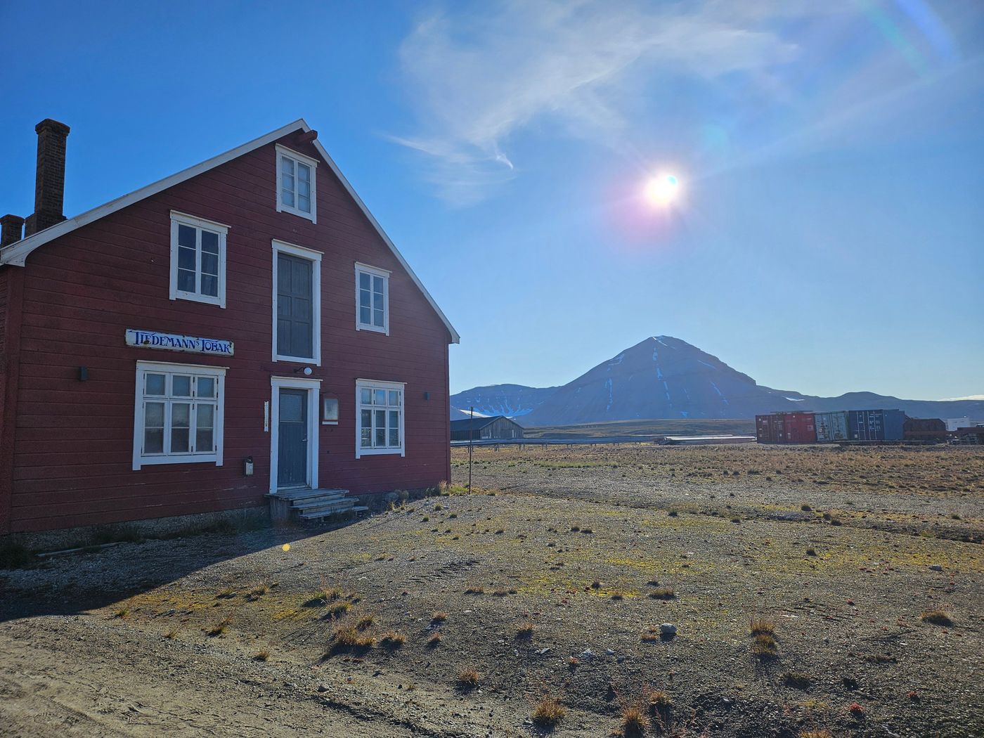 Red painted timber hut under the low midnight sun