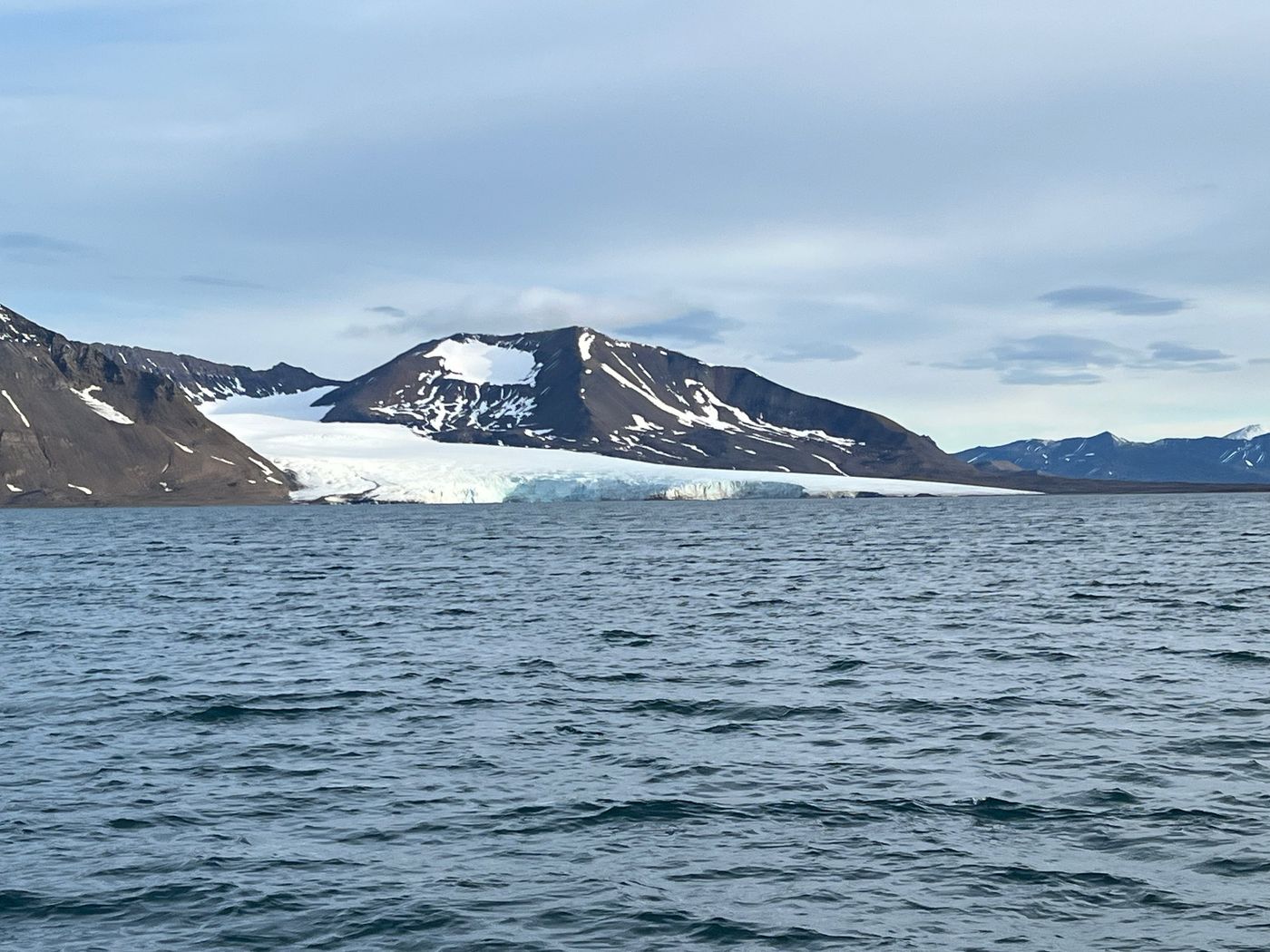 An ice cap ends in a cliff above the sea