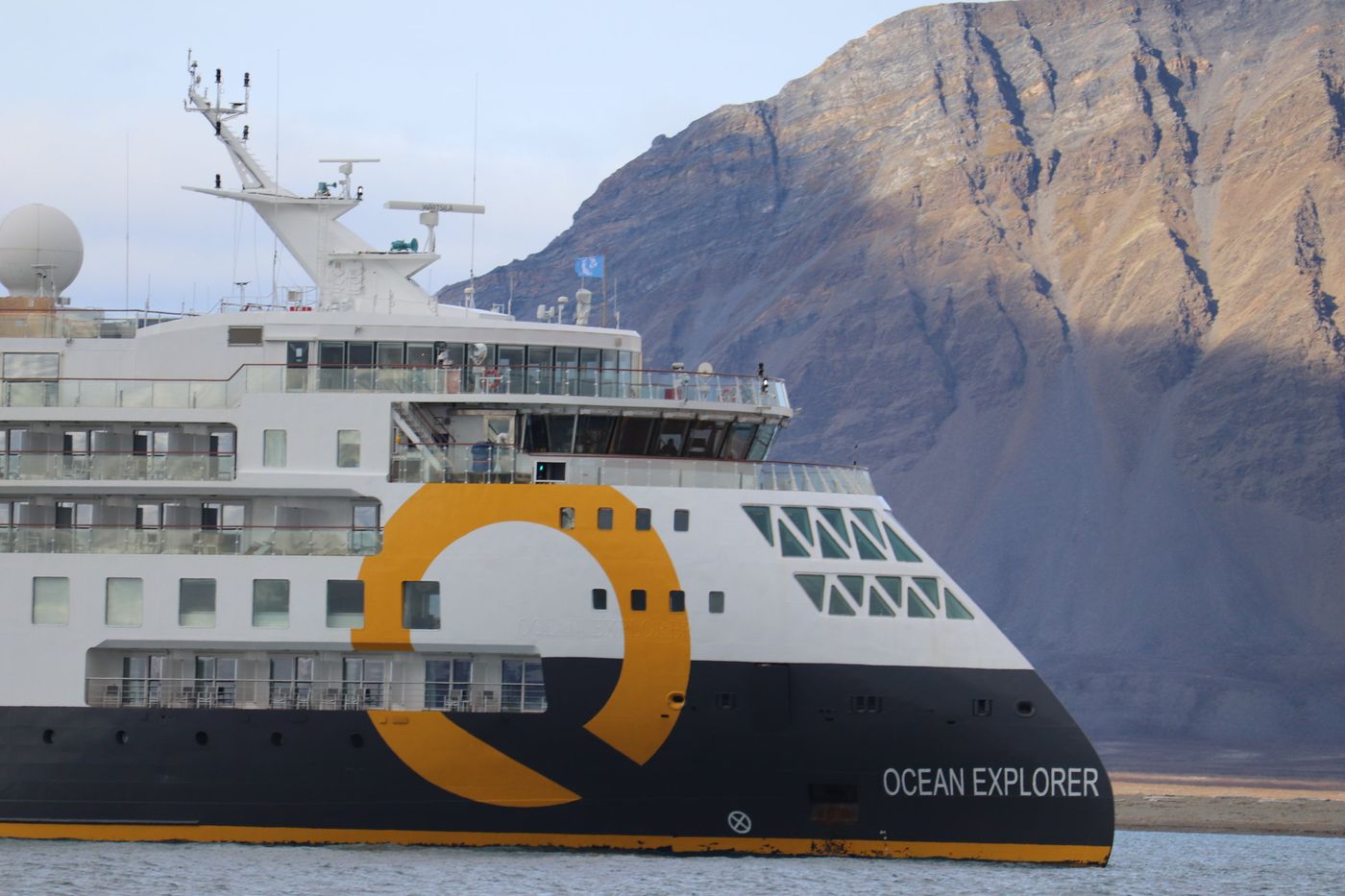 Ocean Explorer's bow under a Kongsfjorden cliff