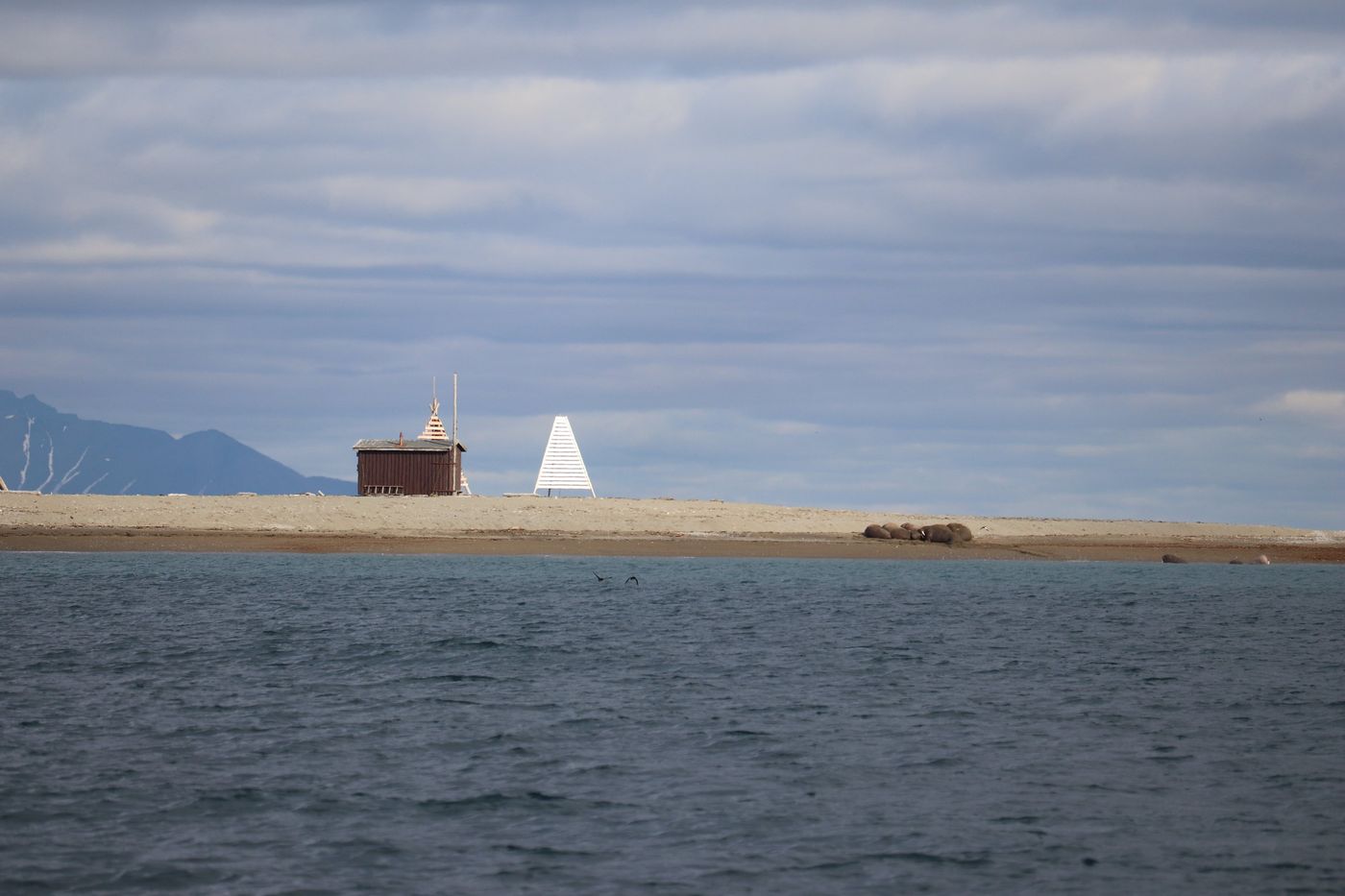 A hut and a beacon alone on a low sand spit