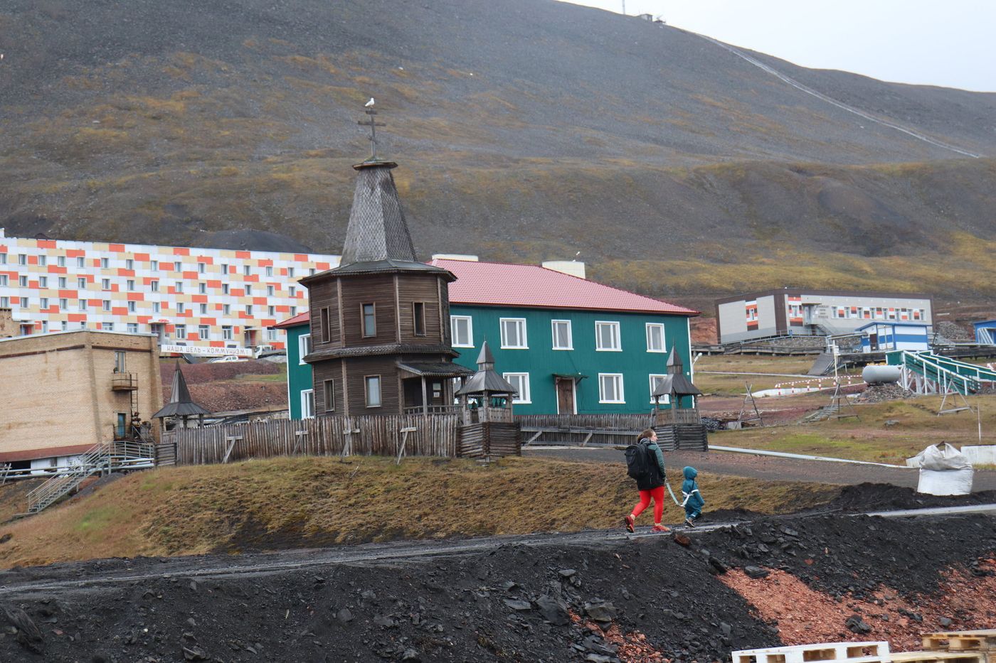The wooden Orthodox chapel above the green houses