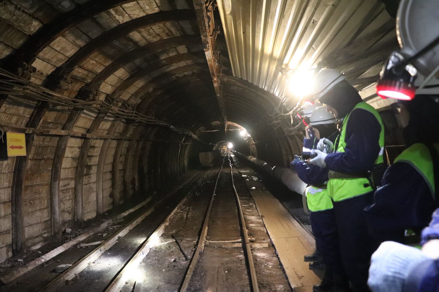 Headlamps and rails deep in the working mine