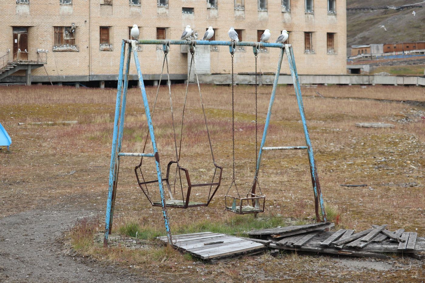 An empty swing frame in front of the blocks