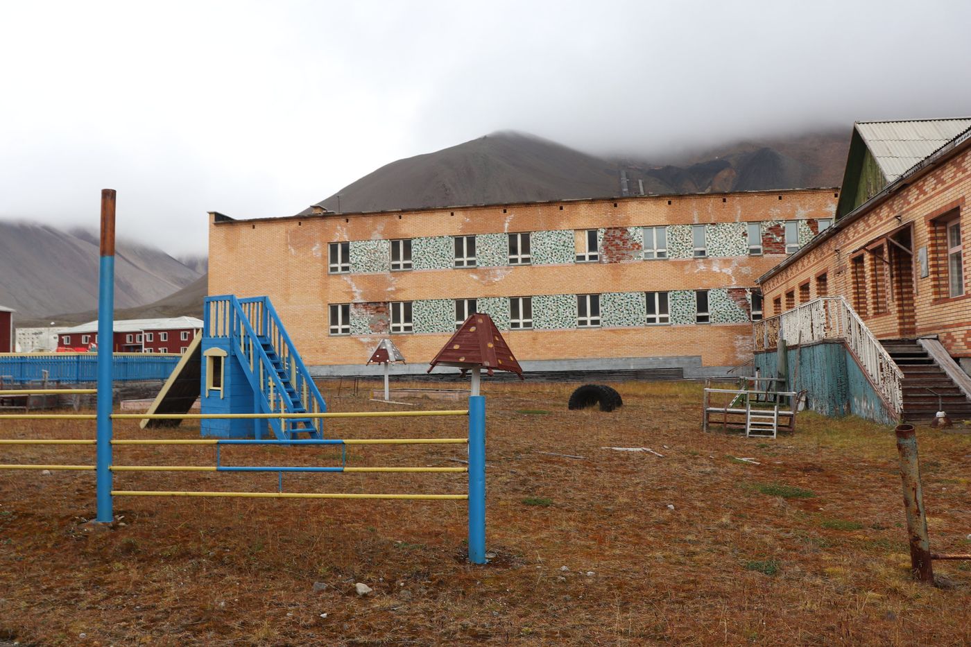 Blue climbing frames outside the painted kindergarten