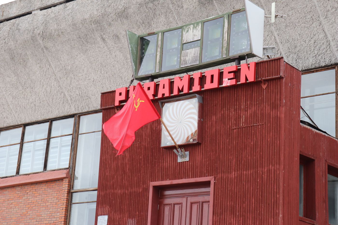 The red PYRAMIDEN sign with a Soviet flag beside it