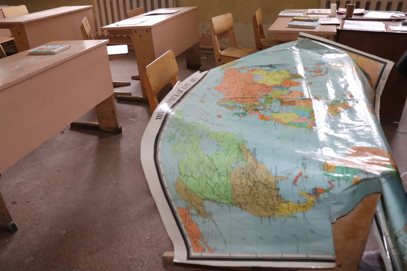 A world map unrolled across the school desks
