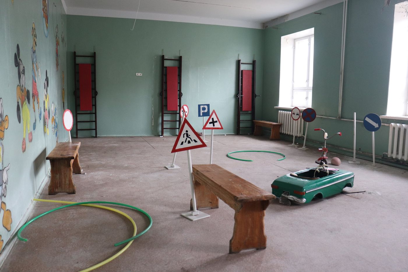 Toy traffic signs and a pedal car in the school hall