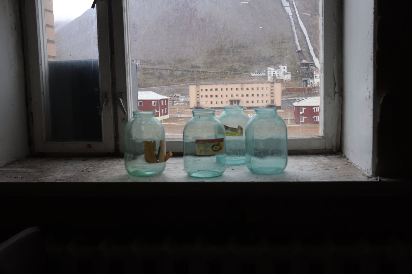 Preserving jars on a sill, the town beyond the glass