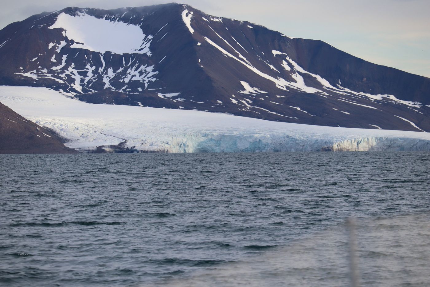 A blue ice cliff standing straight out of the water
