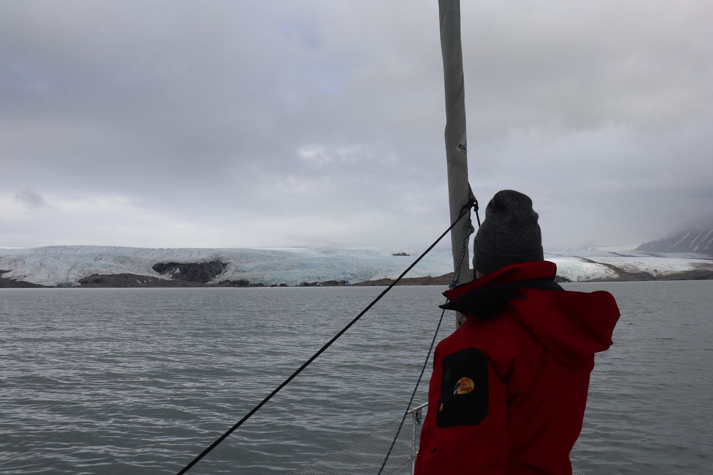 A red jacket at the rail facing the ice front