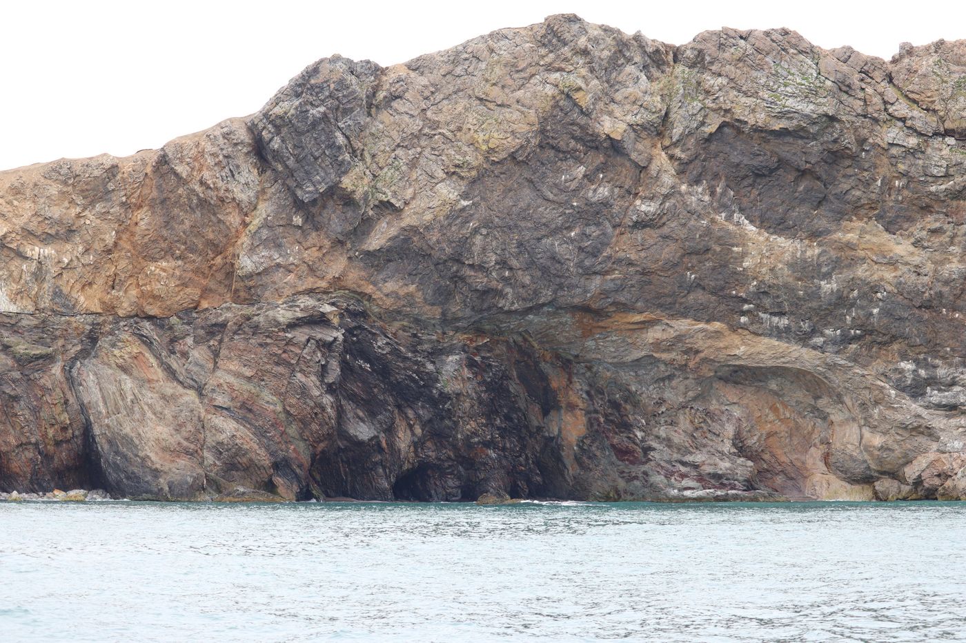 Surf breaking through a Bear Island rock arch