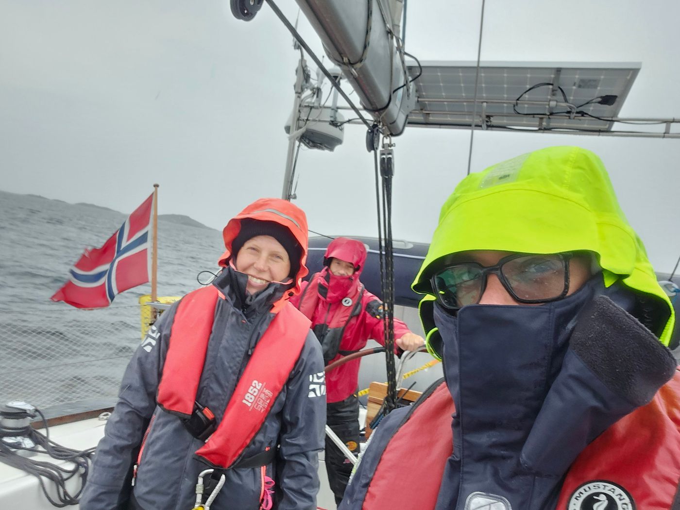 Crew wedged in the cockpit under a wet Norwegian ensign