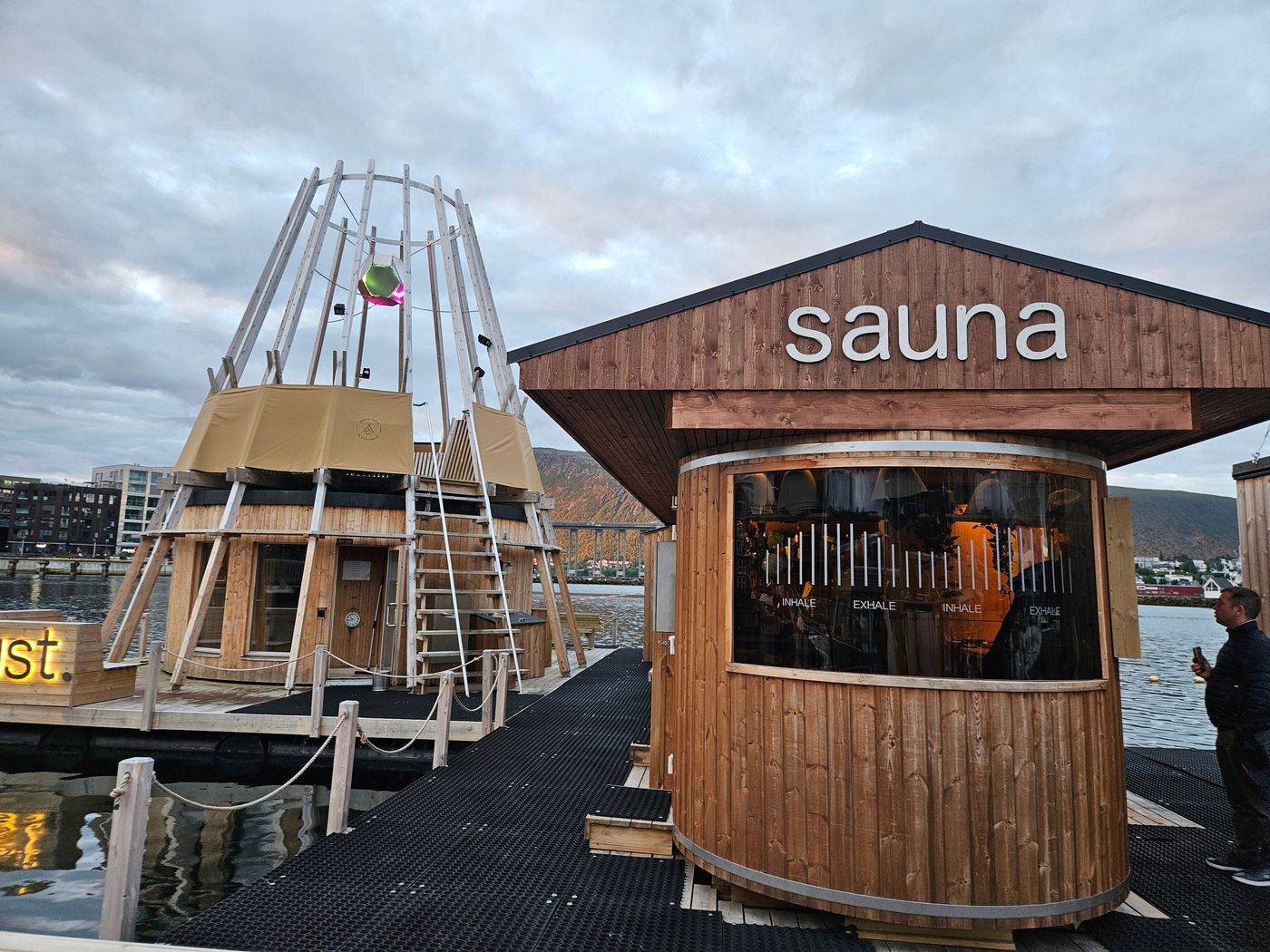 A barrel sauna floating at the quay at 69 degrees north